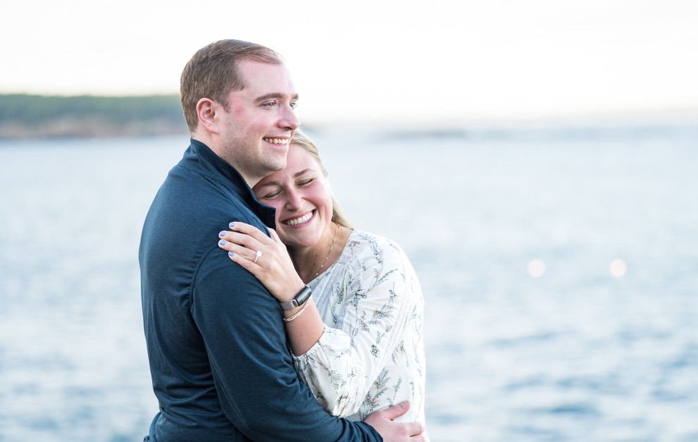 Cecylia resting her head on Gregory's shoulder by the water