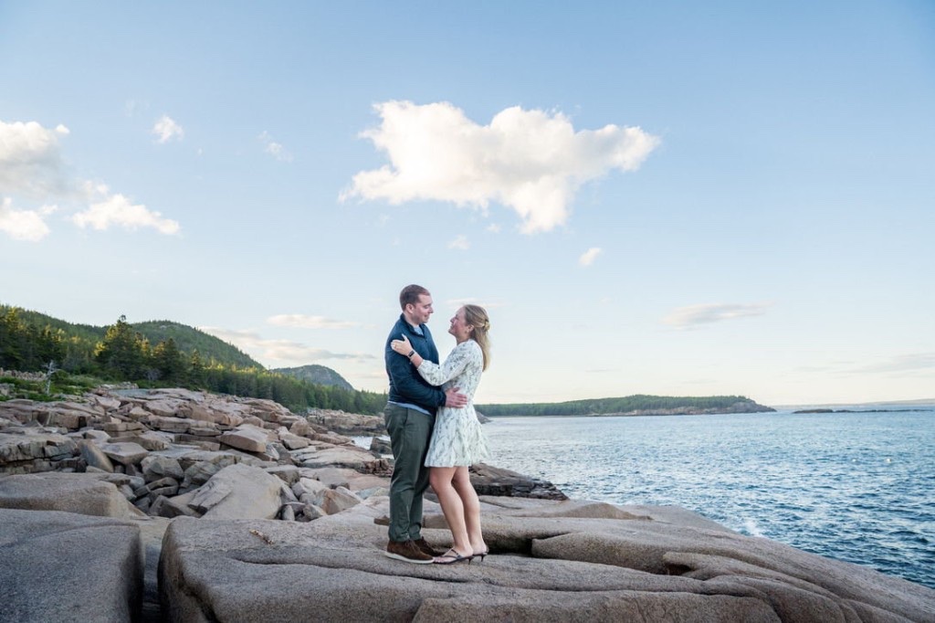 Cecylia and Gregory standing face to face on granite rocks above the sea