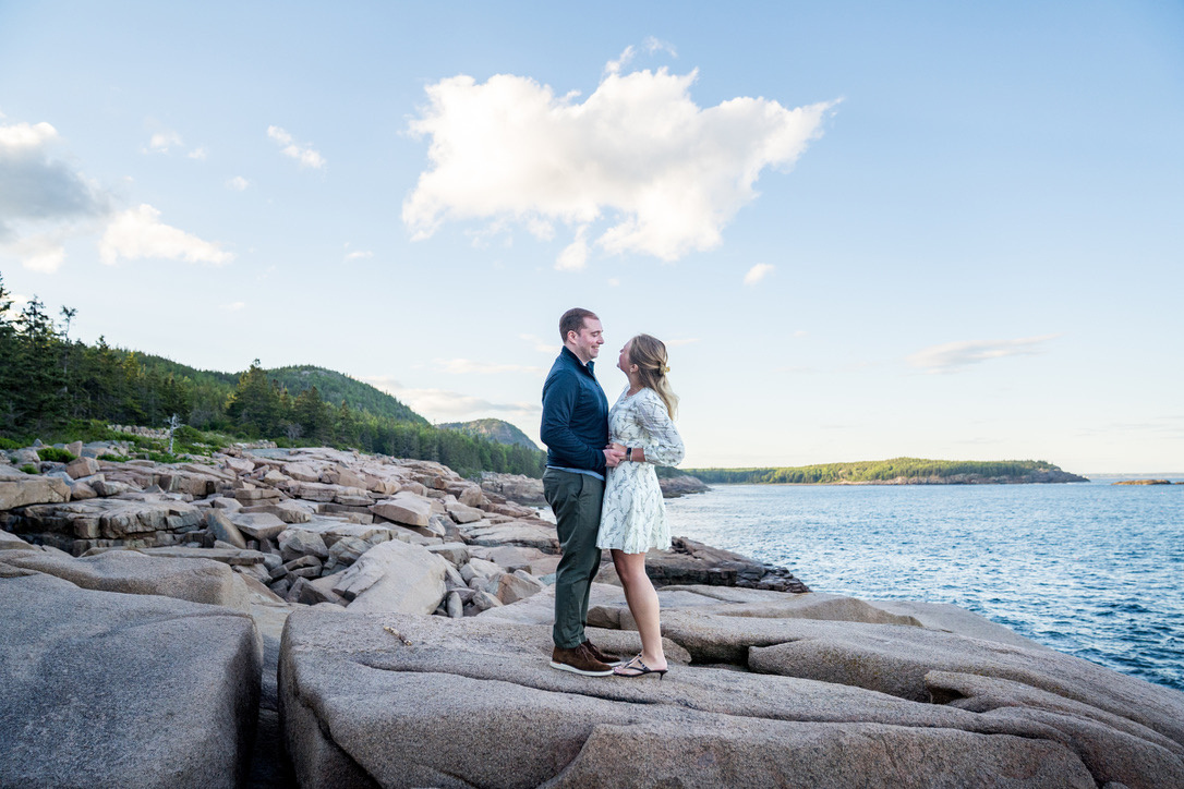 Cecylia and Gregory standing face to face on granite rocks above the sea